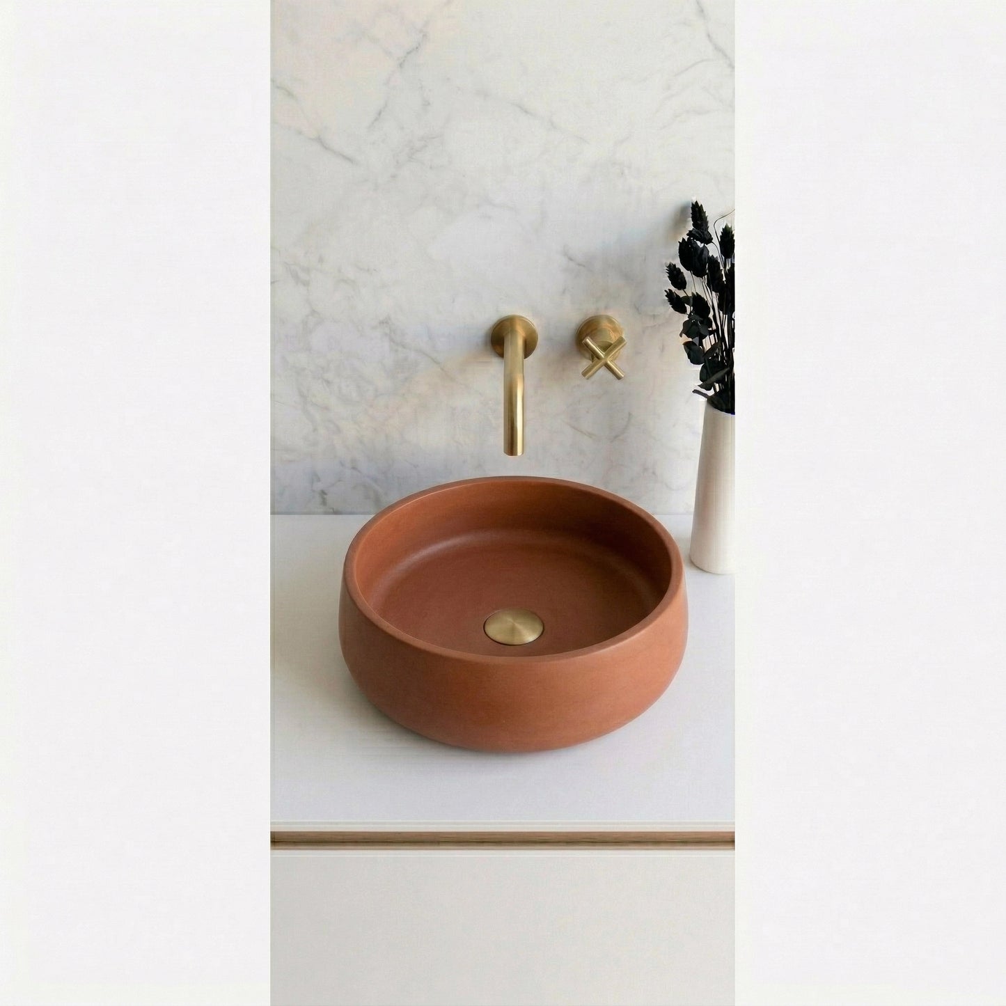 Round terracotta clay concrete stone vessel sink on modern mediterranean minimalist bathroom vanity with brass faucet