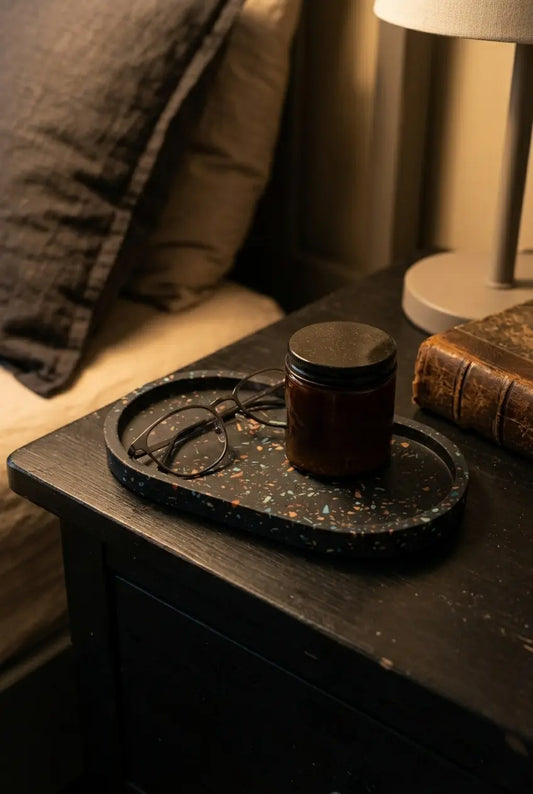 Black terrazzo bedside tray with glasses and candle on nightstand, handmade oval catchall tray for bedroom decor, jewelry, keys and daily essentials