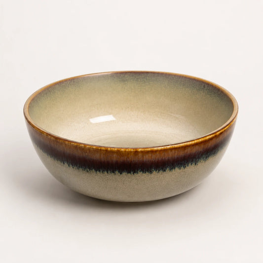 Beige ceramic matcha bowl with brown rim and speckled glaze