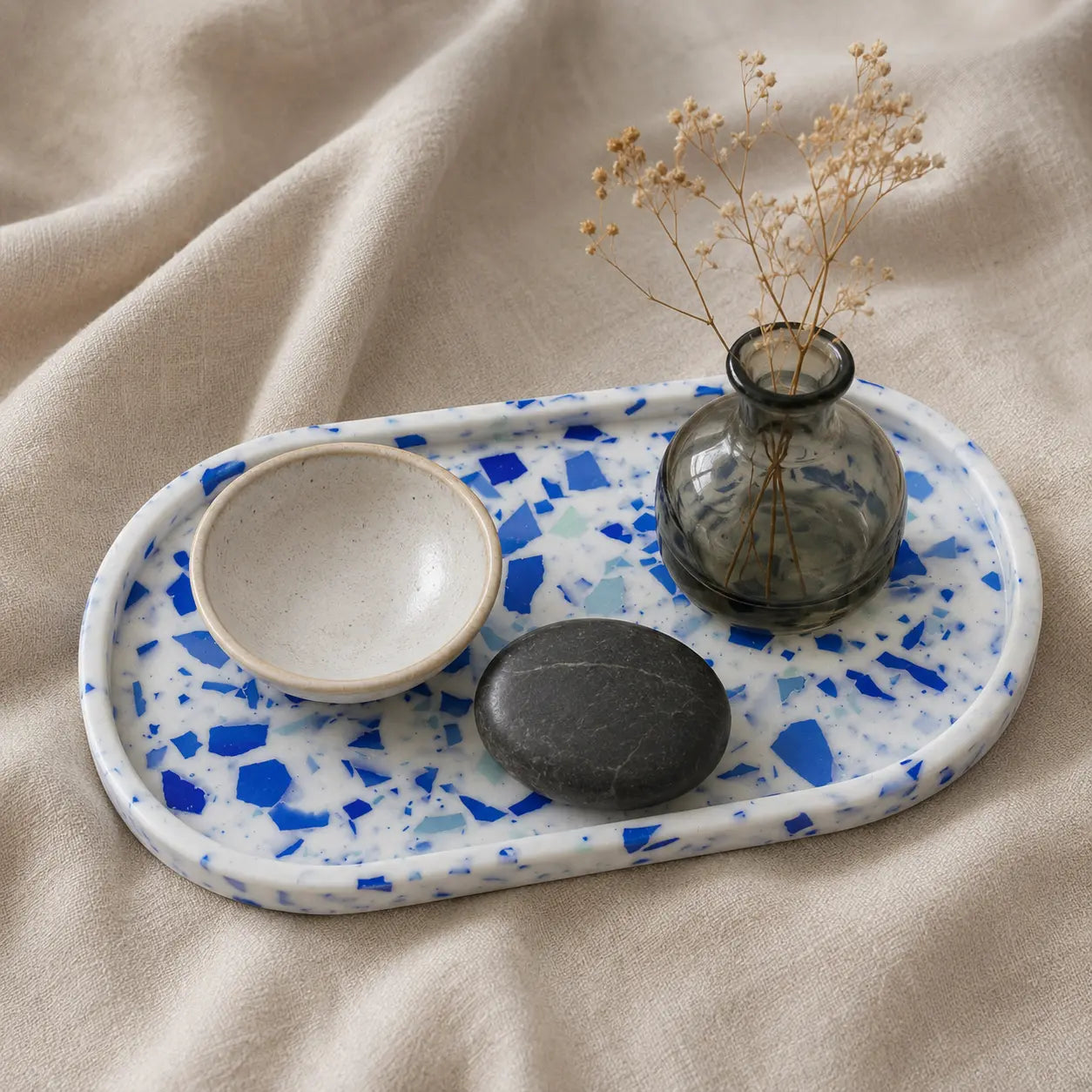 Blue terrazzo bathroom vanity tray styled with bowl, stone, and glass vase