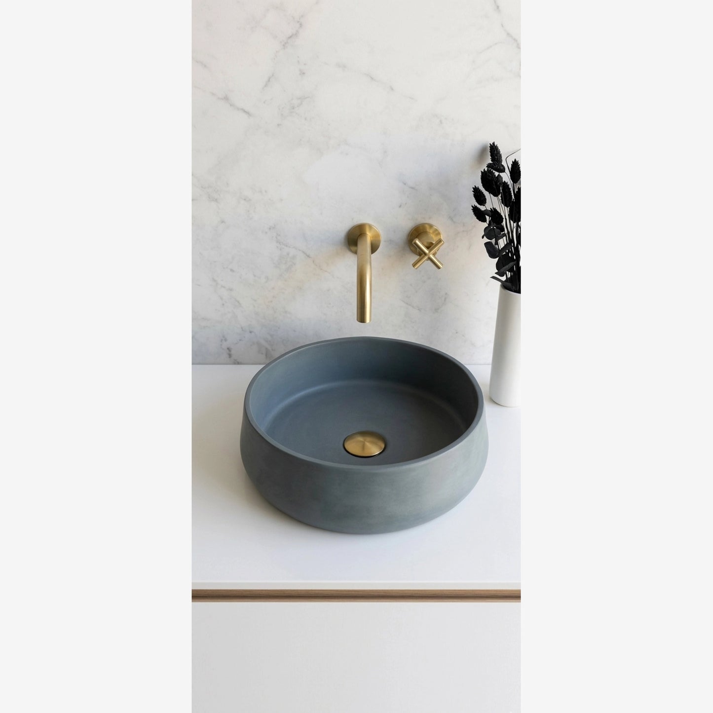 Round concrete stone vessel sink in sage green color for modern minimalist spa bathroom decor with brass faucet