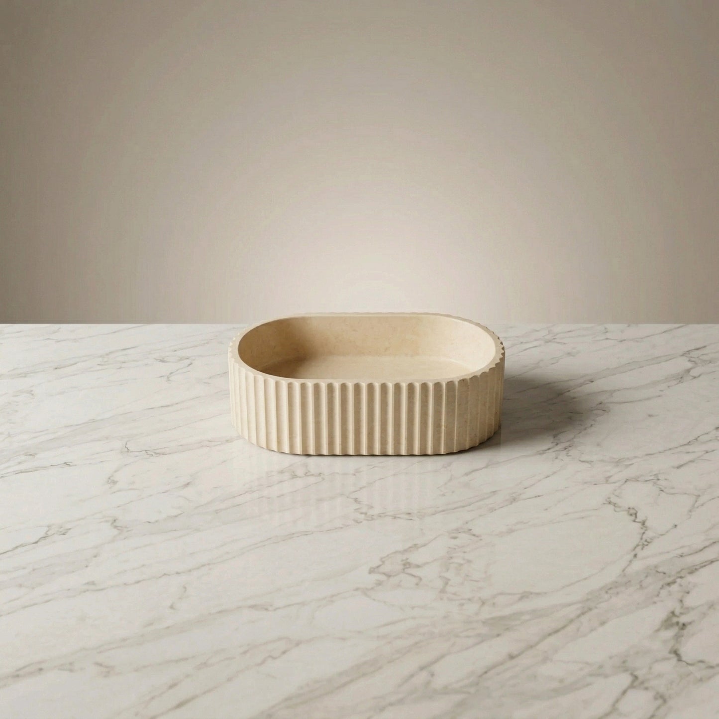 Cream oval fluted vessel sink on marble countertop in a modern minimalist bathroom