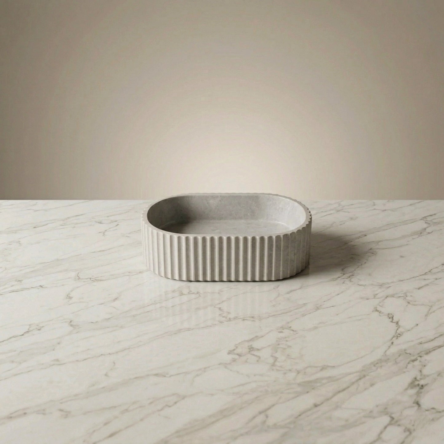 Light gray oval fluted vessel sink on marble countertop in a modern bathroom